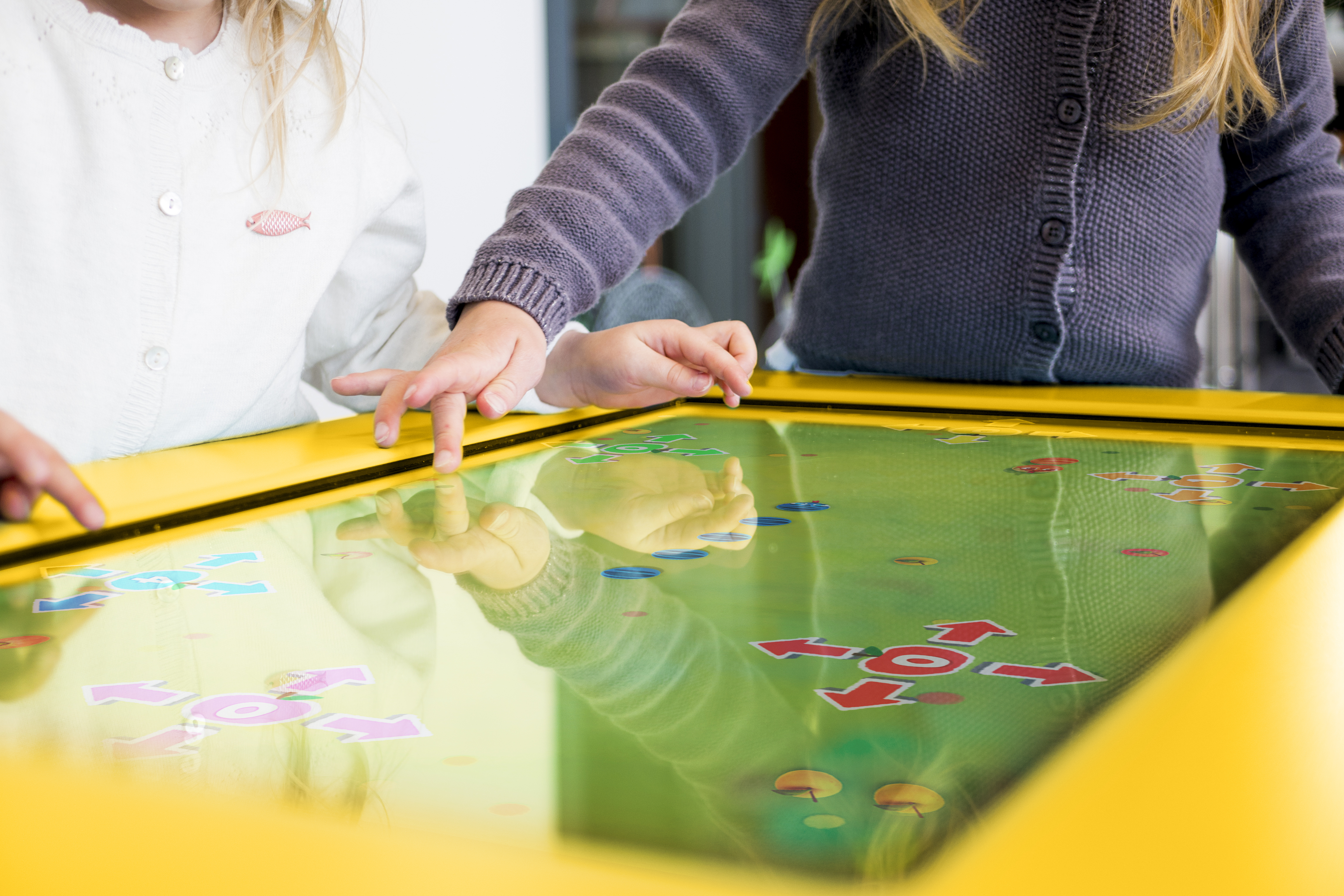 enfant jouant sur table tactile en point de vente